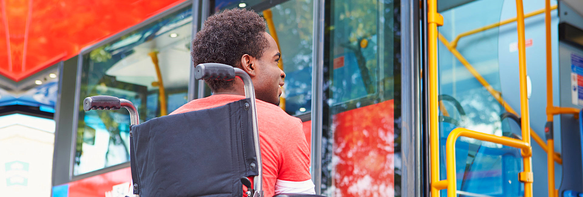 disabled man in a wheelchair boarding a bus