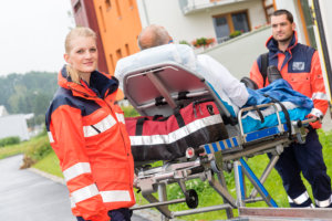 a patient on a stretcher with two paramedics
